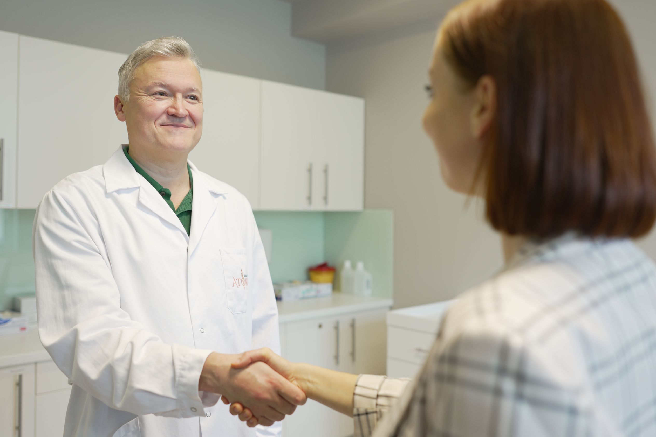Prof. Dr. Florian Roka begrüßt eine Patientin per Handschlag